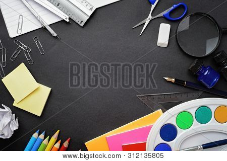 school supplies on black chalkboard background. back to school