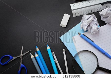 school supplies on black chalkboard background. back to school