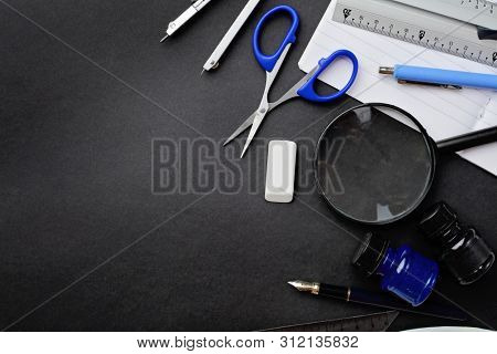 school supplies on black chalkboard background. back to school