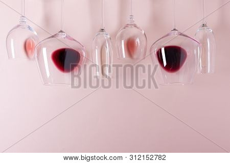 Assorted Wineglasses With Red, Rose And White Wine Lying Top Edge On Pink Background. Wine Degustati