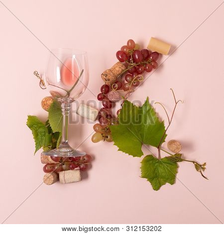 Alphabet. Letter K Made Of Wineglasses With Rose And White Wine, Grapes, Leaves And Corks Lying On P