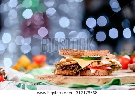 New Years Sandwich With Chicken, Tomatoes, Cheese, Sauce And Lettuce On A Wooden Board. Against The 