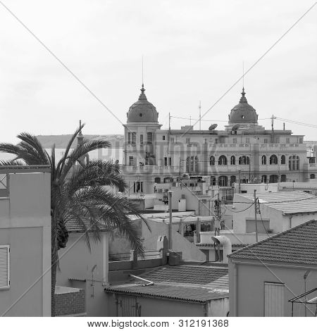 Palm Tree And Casa Carbonell. Scene In Alicante, Spain.