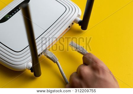 Hand Conncecting The Ethernet Wire Cable With Wi-fi Remote Point