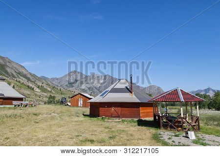 The Ancient Antique Ail House From Wood Is Round-shaped With A Chimney On Top Of The Center, For The