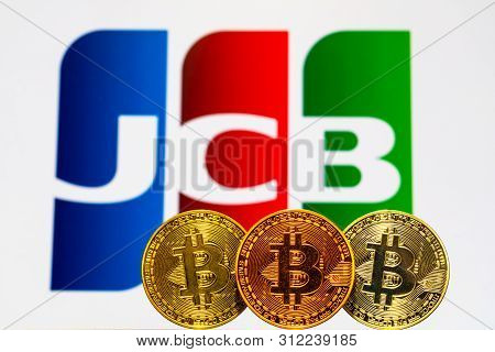 Gold Bitcoin Coins With The Jcb Logo On Background Screen. A New Type Of Business Finance Concept. T