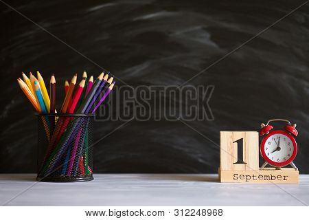 Concept Back To School. Re Alarm Clock With Color Pencils And Wooden Calendar Set On 1St September O