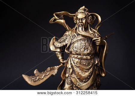 The Statue Of Kwnao Guanyu Of The Goddess Of Integrity Of China On Black Background. Kwnao Fighter W
