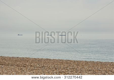 Cargo Ships Moored Off Of Shoreham Harbour In West Sussex, England. Viewed From Lancing, With Mist A
