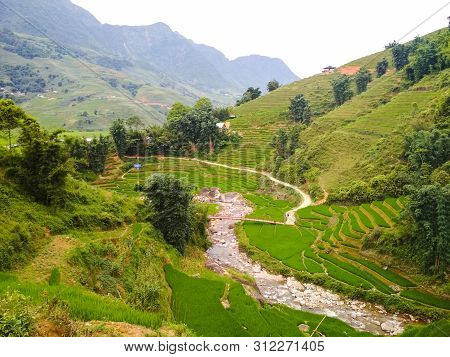 Bright Green Rice Fields Surrounded By Local Village And High Mountains. Travel And Explore The Worl