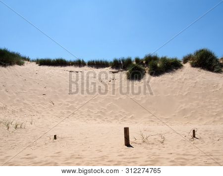 Grass On The Top Of Sand Dunes Near The Beach On The Sefton Coast In Merseyside With Blue Summer Sky