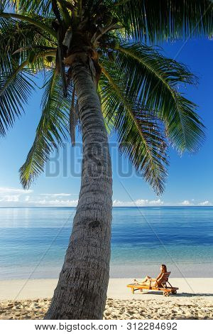 Young Woman Sitting In A Sun Chair On The Beach, Nacula Island, Yasawas, Fiji