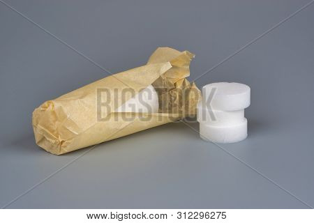 Hexamine Solid Fuel Wrapped In Paper On Gray Background