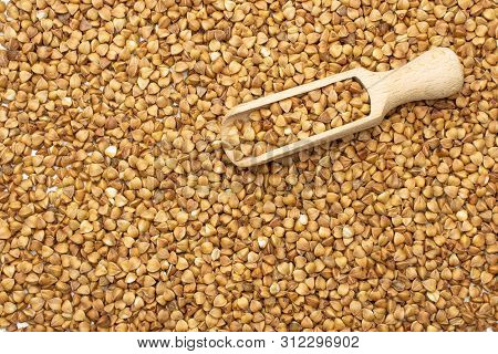 Lot Of Whole Raw Brown Buckwheat Grain Macro With Wooden Scoop Flatlay Isolated