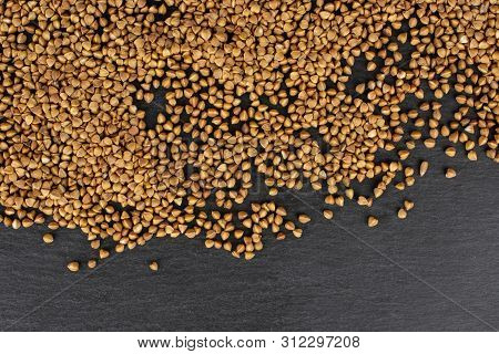 Lot Of Whole Raw Brown Buckwheat Grain Copyspace Flatlay On Grey Stone