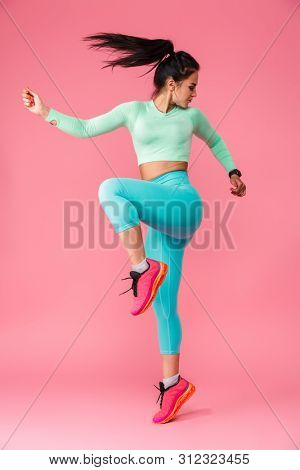 Picture of amazing concentrated young sports fitness woman isolated over pink wall background make exercises.
