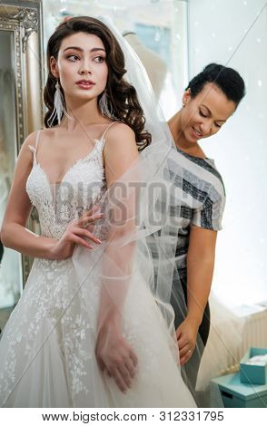 Beautifu bride choosing wedding dress in a wedding salon