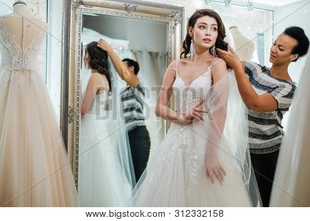 Beautifu bride choosing wedding dress in a wedding salon