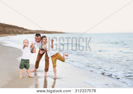 Father And Two Sons Show Class, Sea Coast. Enjoying Vacation