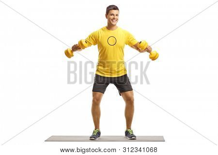 Full length portrait of a young man exercising on a mat with weigths isolated on white background