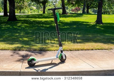 Boise, Idaho - July 14, 2019: A Lime Brand Dockless Electronic Scooter Sits On A Sidewalk, Unattende