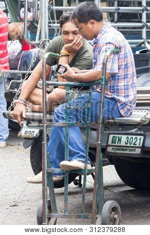 Bangkok, Thailand - November 12th 2015: Two Men Looking At A Mobile Phone On Pak Khlong Talt Market.