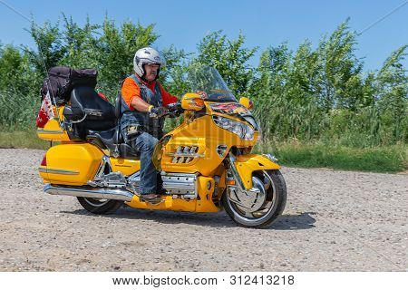 Eger, Hungary - July 04, 2019: Motor Biker At Yellow Honda Goldwing Making A Drive Through Hungary B