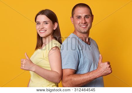 Manetic Cheerful Man Standing Back To Back To Young Brunette Woman, Raising Hands, Making Gesture, S