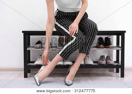 Woman Putting On Shoes Indoors, Closeup. Stylish Hallway Interior
