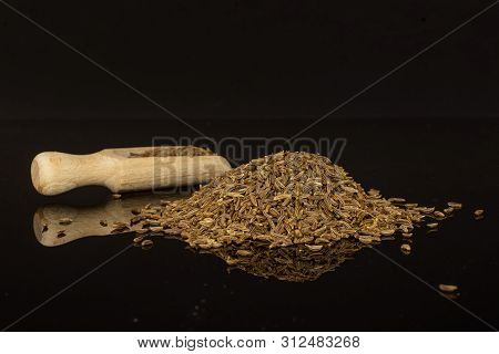 Lot Of Whole Dry Caraway Fruits Heap With Wooden Scoop Isolated On Black Glass