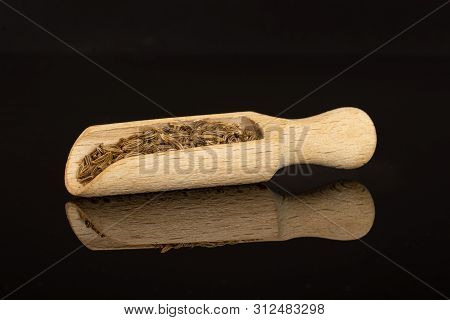 Lot Of Whole Dry Caraway Fruits With Wooden Scoop Isolated On Black Glass