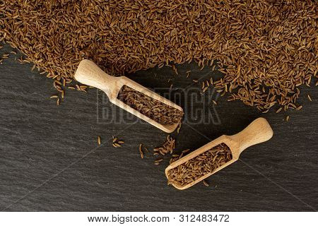 Lot Of Whole Dry Caraway Fruits With Two Wooden Scoops Flatlay On Grey Stone