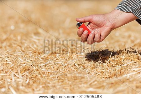 Arsonist, Hand Holding A Lighter Near A Haystack