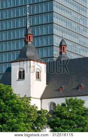 Old Church And Monastery St. Heribert In Front Of A Modern Office Building, Cologne, Germany