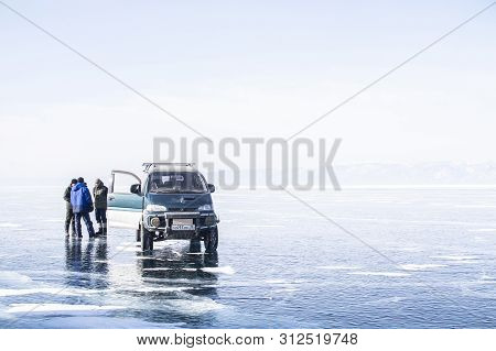 Bikal Lake, Siberia, Russia - February 23, 2019: Car Is Parking On Frozen Lake In Russia And People 