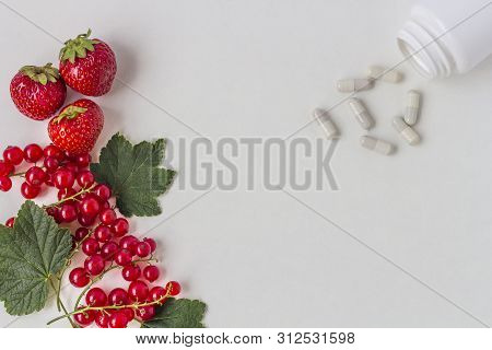 Vitamins Supplements As A Capsule With Fresh Berries From The Medicine Jar On White Background. The 