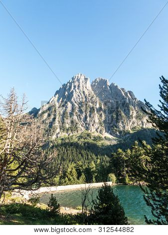 Pond Of Sant Maurici, In The Aiguestortes And Sant Maurici National Park. The Peak Amitges On Backgr