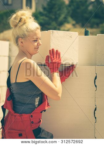 Strong Pretty Woman Working On Construction Site, Building House, Installing Gray Airbricks. Industr