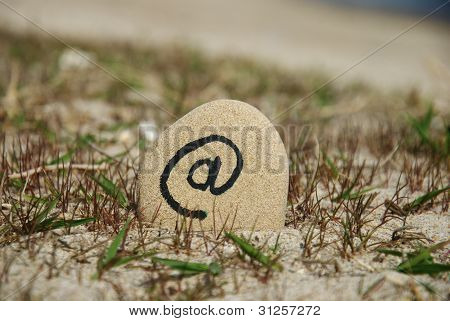 at sign on a stone beach background