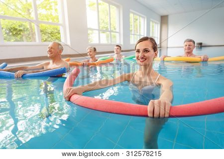 Patients during remobilization in a health center doing aquarobics in the water of a pool