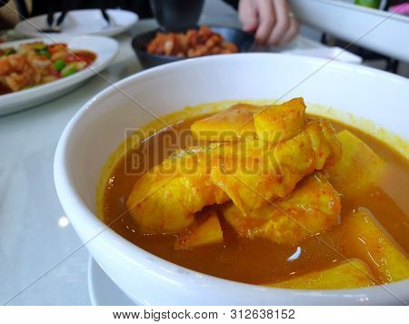 Thai Food Style,top View Sour Soup With Snapper And Young Coconut Shoots In White Bowl At Restaurant