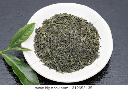Dried Tea Leaves With Green Tea Leaves On Black Background