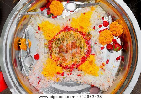 colorful boiled rice decorated with flowers and dry fruit_sweet casserole, in steel plate with black background