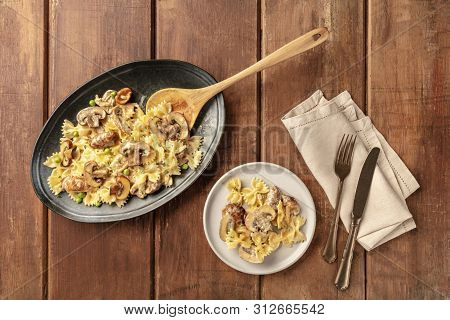 Mushroom Pasta. Farfalle With Cremini And Green Peas, Shot From The Top On A Dark Rustic Wooden Back