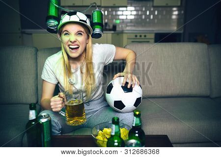 Young Woman Watch Football Game On Tv At Night. Angry Model Sit On Sofa And Hold Glass Of Beer With 