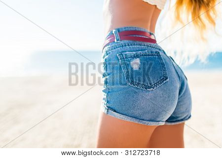 Woman Showing Her Sexy Curves. Hips And Legs Body Part In Short Denim Shorts.
