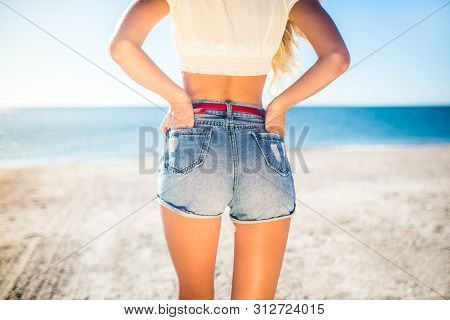 Woman Showing Her Sexy Curves. Hips And Legs Body Part In Short Denim Shorts.