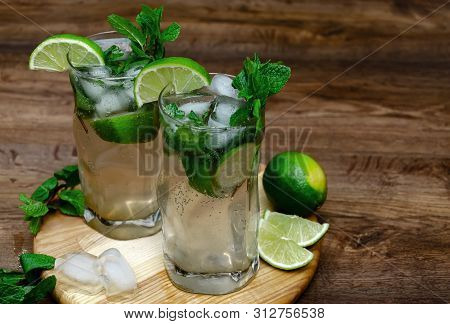 Summer Drink Mojito, Mohito With Mint, Ice And Lime, In Glasses, On A Wooden Table, Macro Photograph