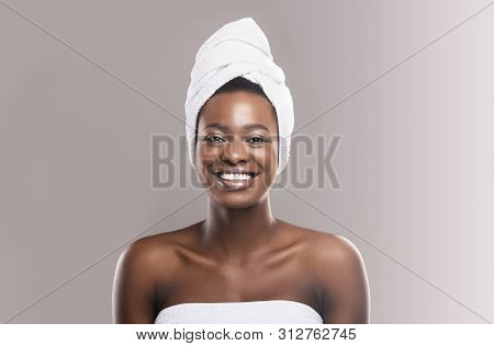 Beautiful Young African Woman Wrapped In White Bath Towel Preparing For Sauna, Grey Studio Backgroun