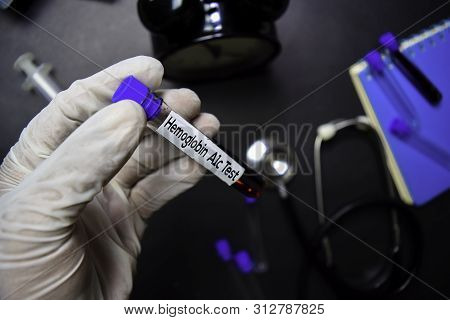 Hemoglobin A1c Test Text With Blood Sample. Top View Isolated On Black Background. Healthcare/medica